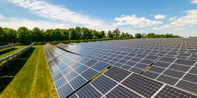 Rows of solar panels set up in open field