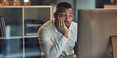 Bored office worker looks at his computer screen