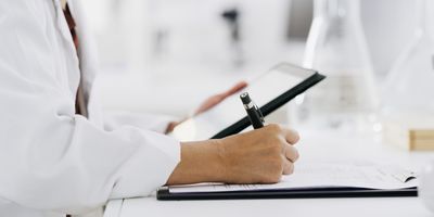 Scientist with tablet, science and writing notes for medical research and digital test results