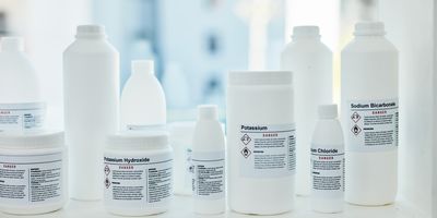 Reagent bottles sit on a shelf in a laboratory