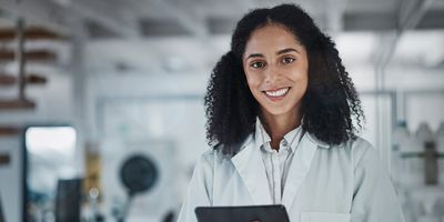 portrait of woman with tablet and smile in laboratory