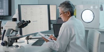 Scientist sits at a computer analyzing data