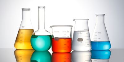 Lab glassware filled with fluids of various colors