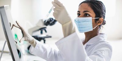 A female scientist looking at a test tube in a lab