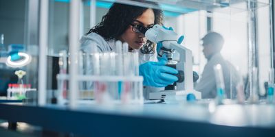 Young student looking at a sample in a microscope