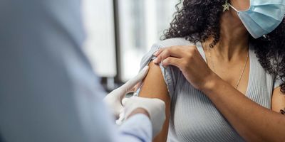 Woman receiving vaccine from doctor