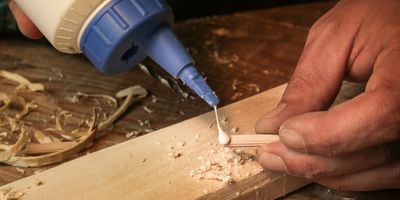 Handyman assembling wooden pieces with a glue