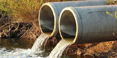 Waterwater pouring out of pipes into a river