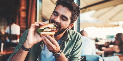 Man eating a burger at a restaurant 