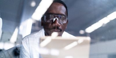 A male scientist in the lab looking at a tablet