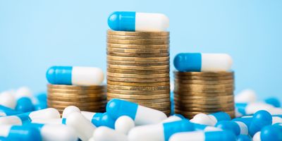 stacks of coins with pills resting on top of each stack