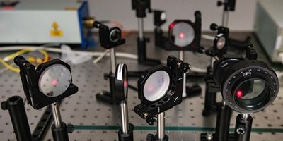 A series of mirrors and prisms deflect lasers and focus them to perform the reaction