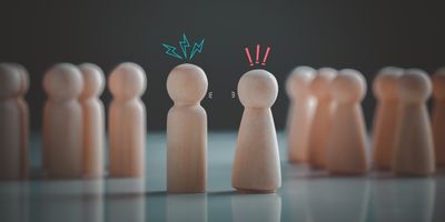 Wooden pegs representing two workers disagreeing with each other