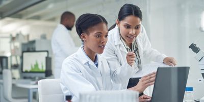 Two scientists discuss results on a computer screen