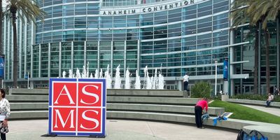 a photo of a red square sign with the letters A S M S in front of a water fountain at the Anaheim Convention Center