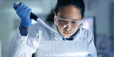  One young, serious and professional medical researcher using a pipette