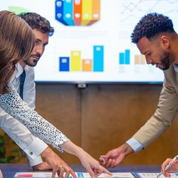 Workers discuss metrics in a conference room