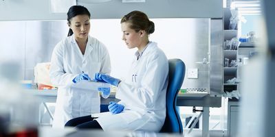 Female colleagues discussing research in modern laboratory