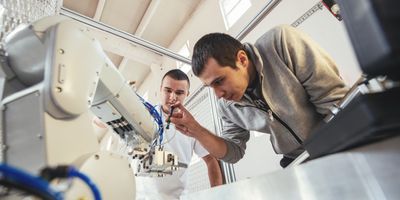 Engineers examining a piece of robotic lab equipment