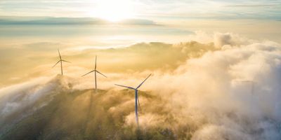 Wind turbines sticking up through the clouds