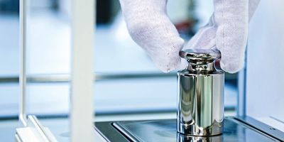 Scientist places a sample on an analytical balance