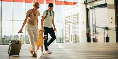 Mother and father walking through airport with young daughter