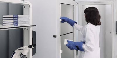 A scientist working in a lab with an ultra-low temp freezer