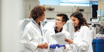 Female scientists discuss project in the lab