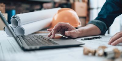 Man works on a lab renovation project on his laptop