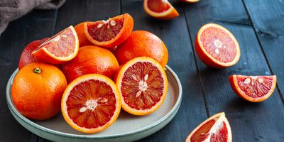 Plate of fresh blood oranges on a wooden table