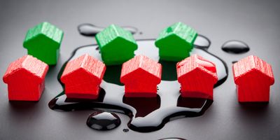 Toy wooden houses in a small puddle of water