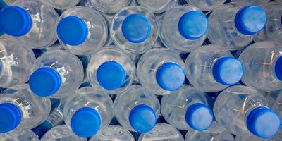 a close up photo of a stack of plastic water bottles with blue caps