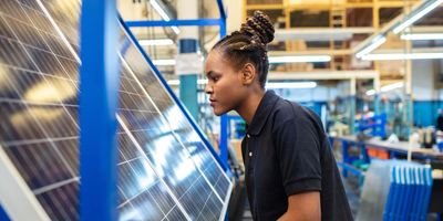 Women engineer inspecting solar panel