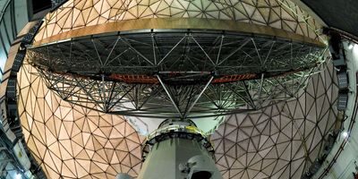 The Haystack Ultrawideband Satellite Imaging Radar, which looks like a massive gold-colored globe covered in a cage of triangles.