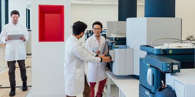 Scientists in a lab discuss equipment maintenance