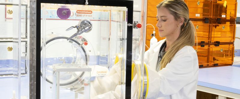 Female scientist uses a Plas-Labs glovebox