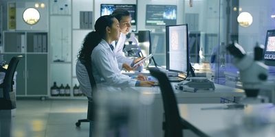 Scientists work at a computer in the lab