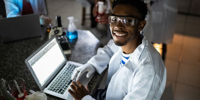 Happy young man studying in lab at school