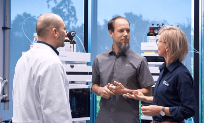 Researchers stand in a lab talking