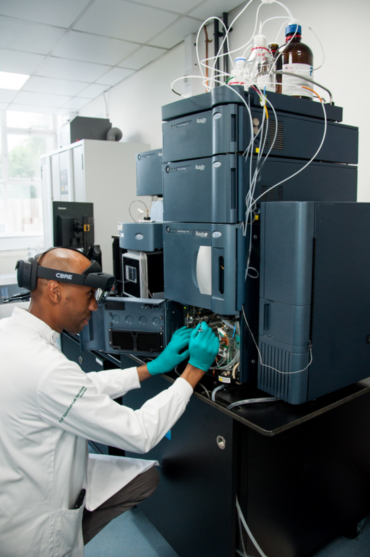 Lab technician services a chromatography system with an XR headset