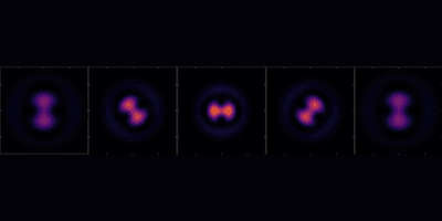 microscopic image of atom positions shown as pink and purple dumbell-like shapes at various angles on a black background